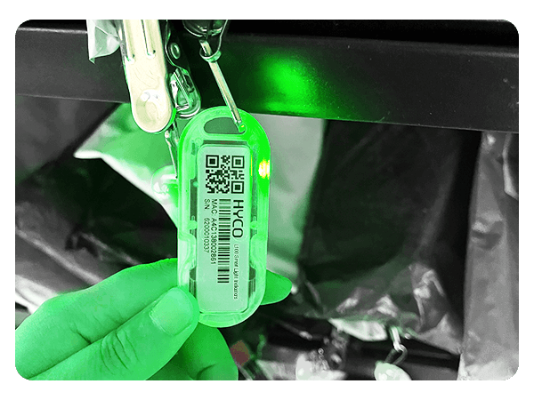 A person is holding a (L102 Chargeable Wireless Light Tag) with a qr code on it.