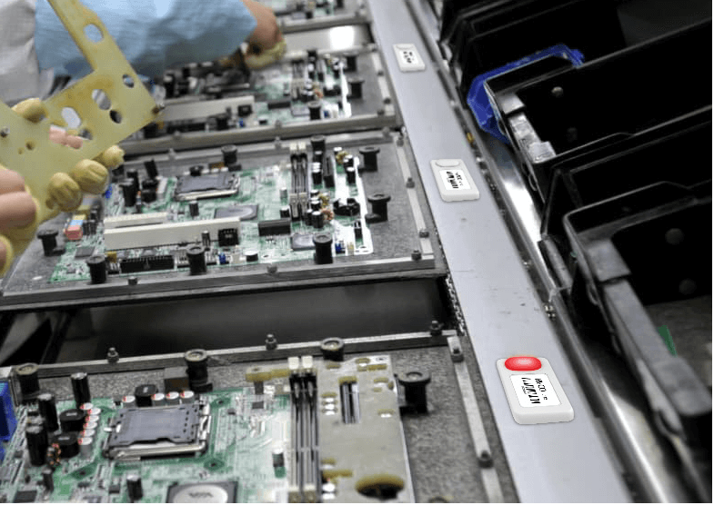 A person is working on a motherboard in a factory with L112 Button-On
Wireless Light Tag