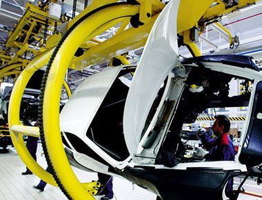 A man is working on a car in a factory