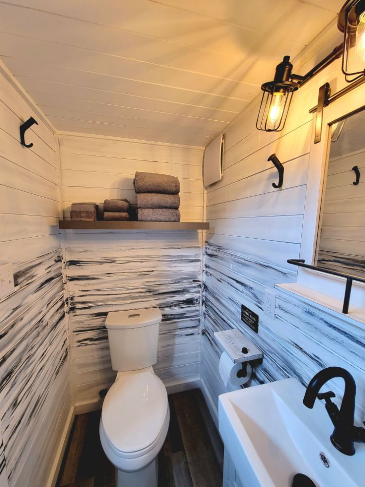 A bathroom with a toilet , sink and mirror.