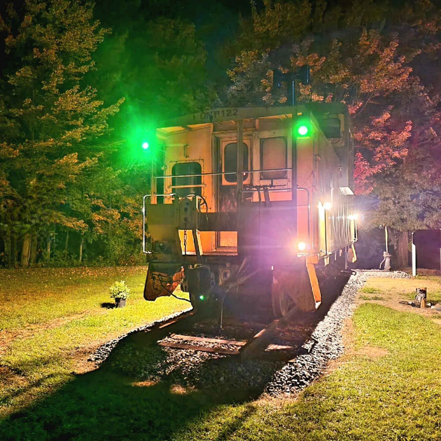 A train is on the tracks at night with the lights on