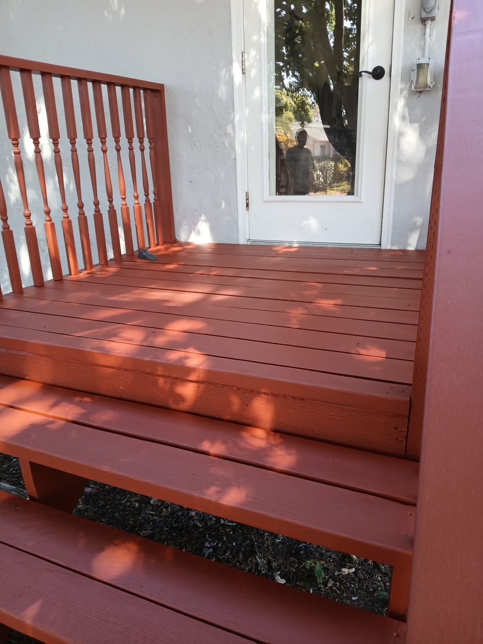  new painted Red wooden porch steps with railings beside a house and door