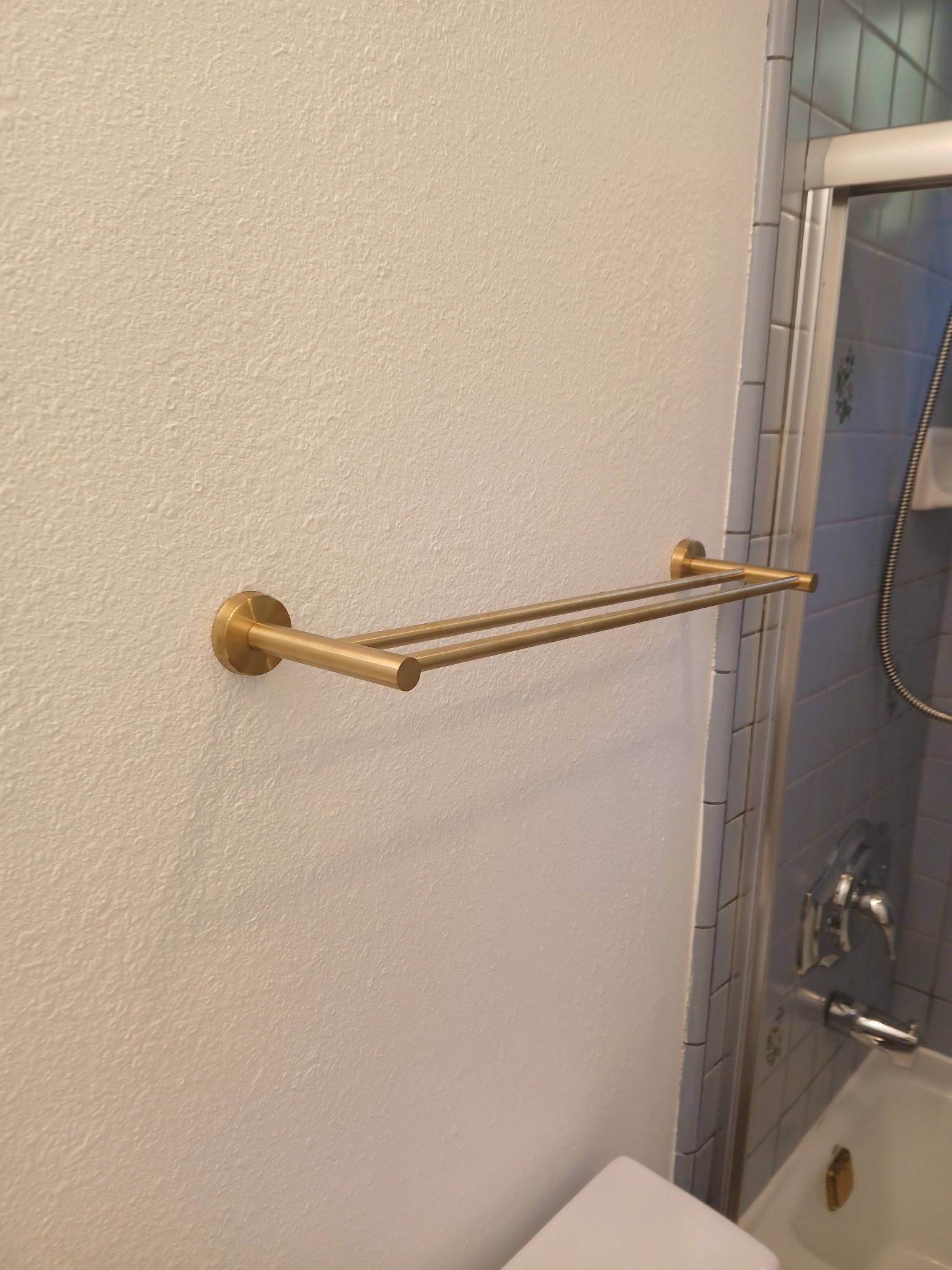 Brass towel bar mounted in bathroom