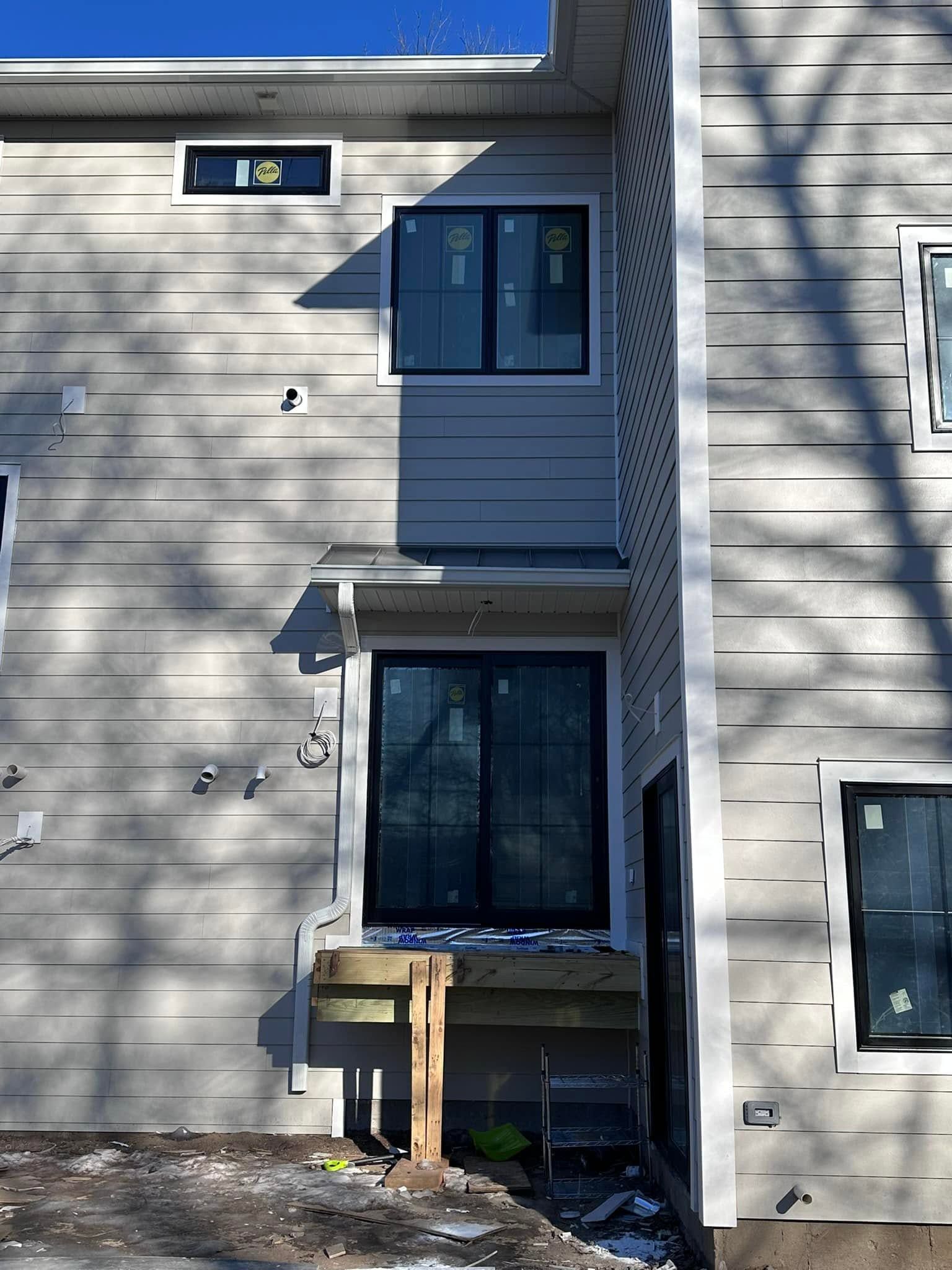 Apartment building exterior with windows, balconies, and a small mailbox near the entrance