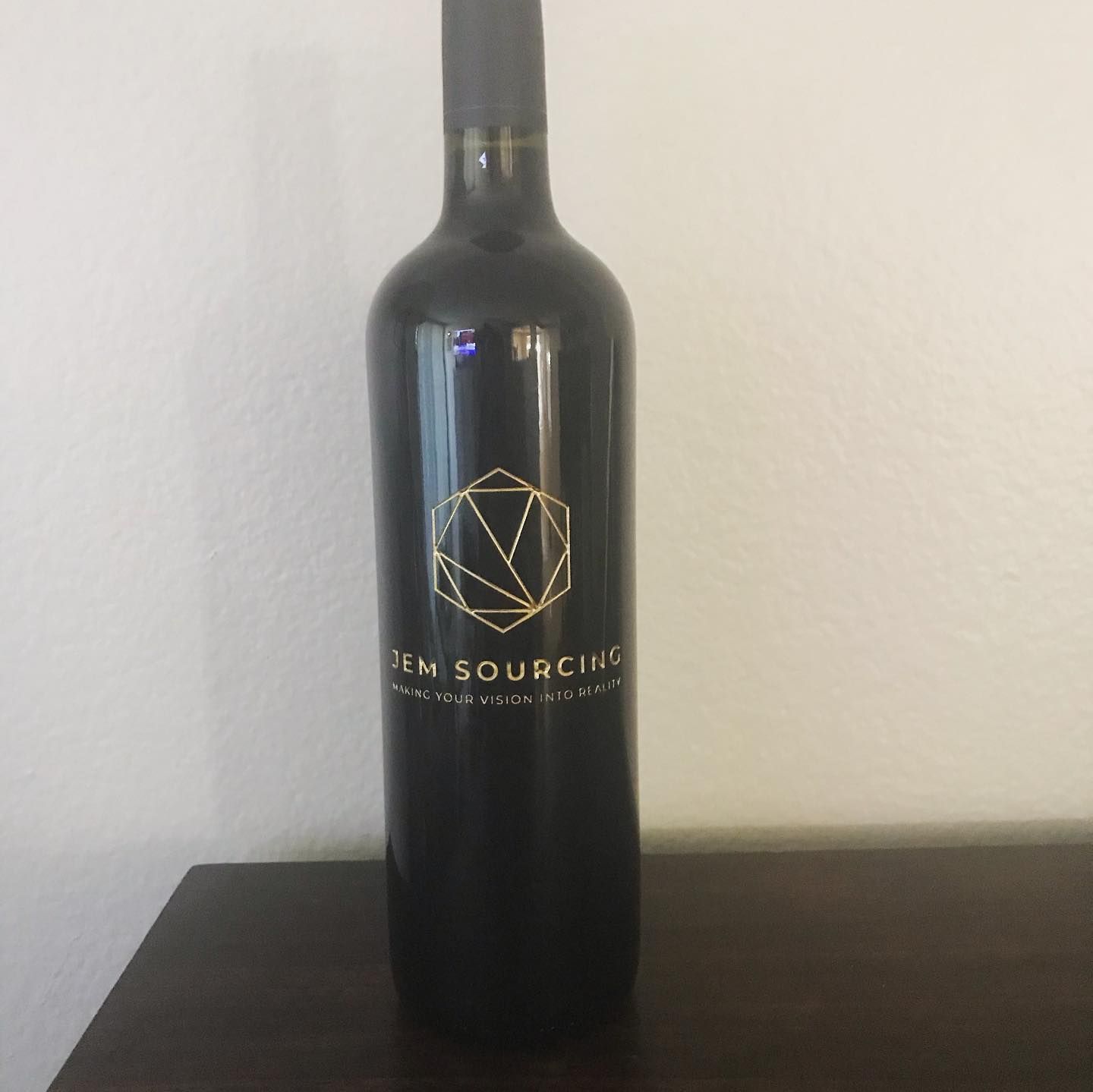 Bottle of dark red wine with gold logo