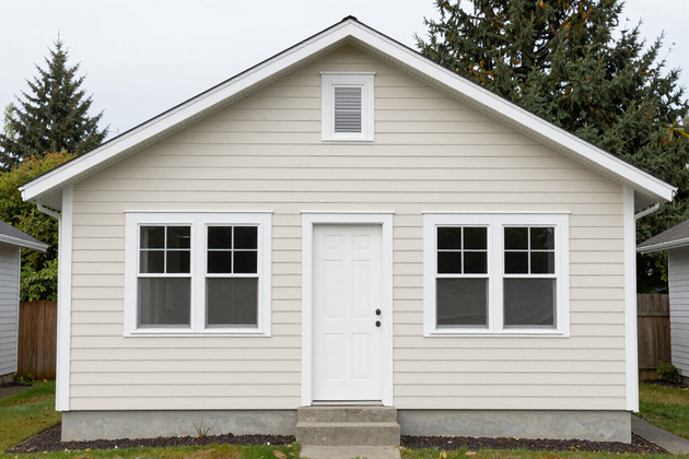 Well-maintained Northwest home with cream vinyl horizontal siding and clean trim details.