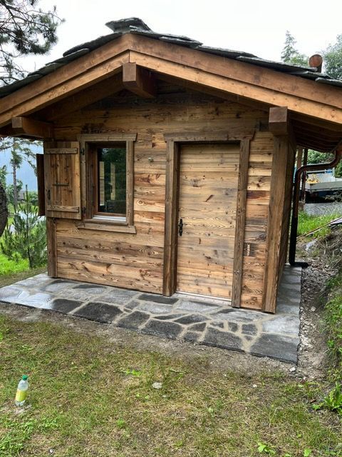 Une petite cabane en bois avec une fenêtre et une porte