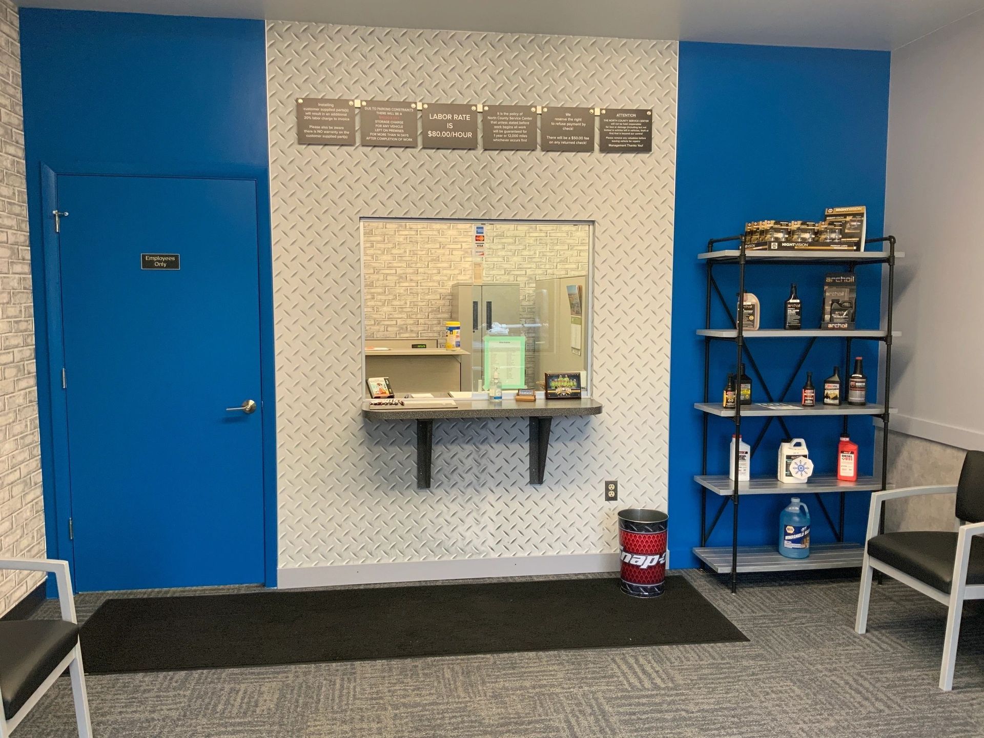A waiting room with a blue door and shelves | North County Service Center