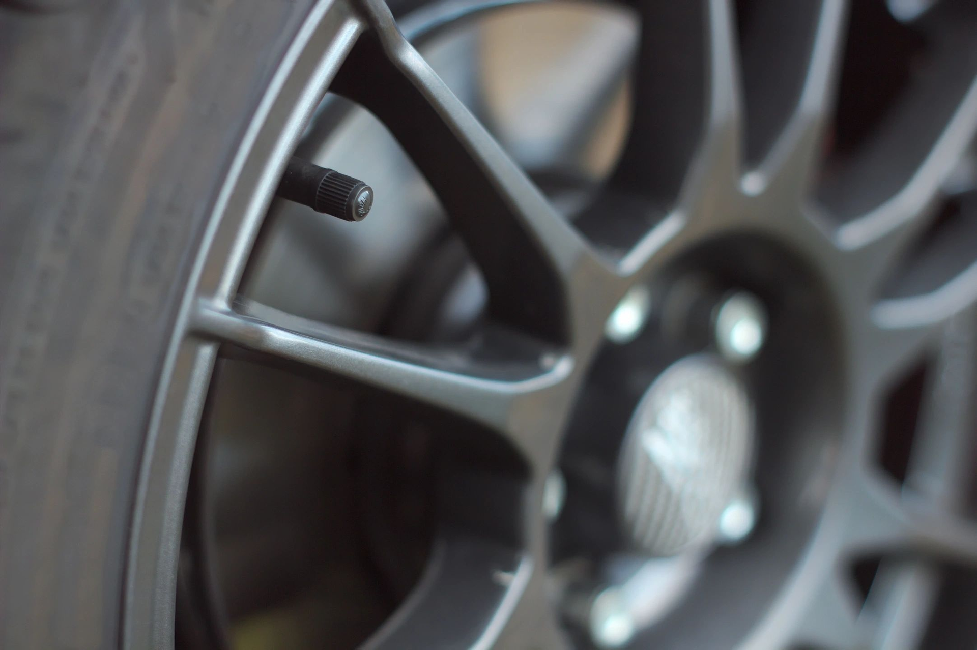 A close up of a car wheel with a tire valve on it. | North County Service Center