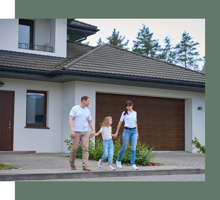 A family is walking down the sidewalk in front of their house holding hands.