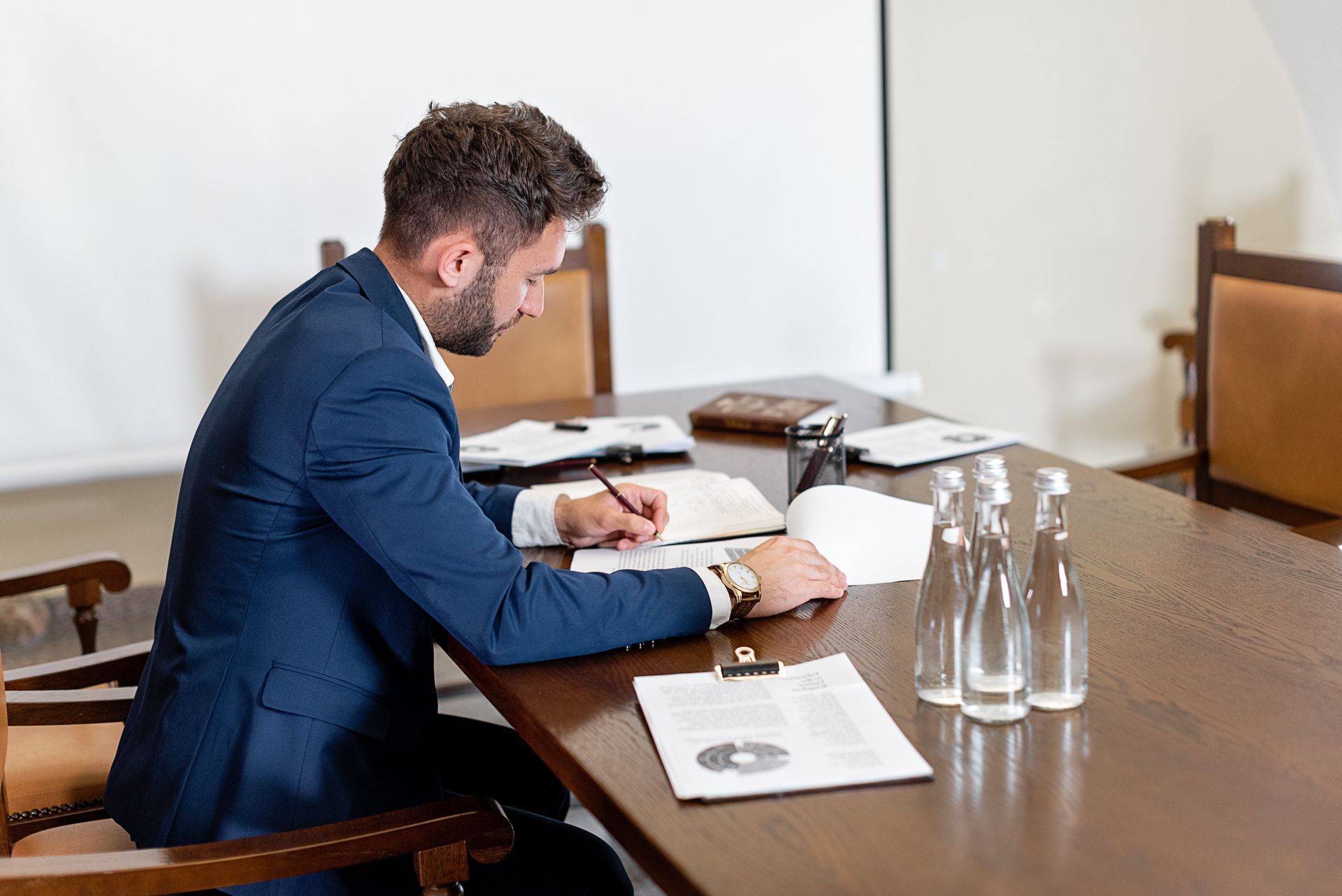 A man in a suit is reading through some documents