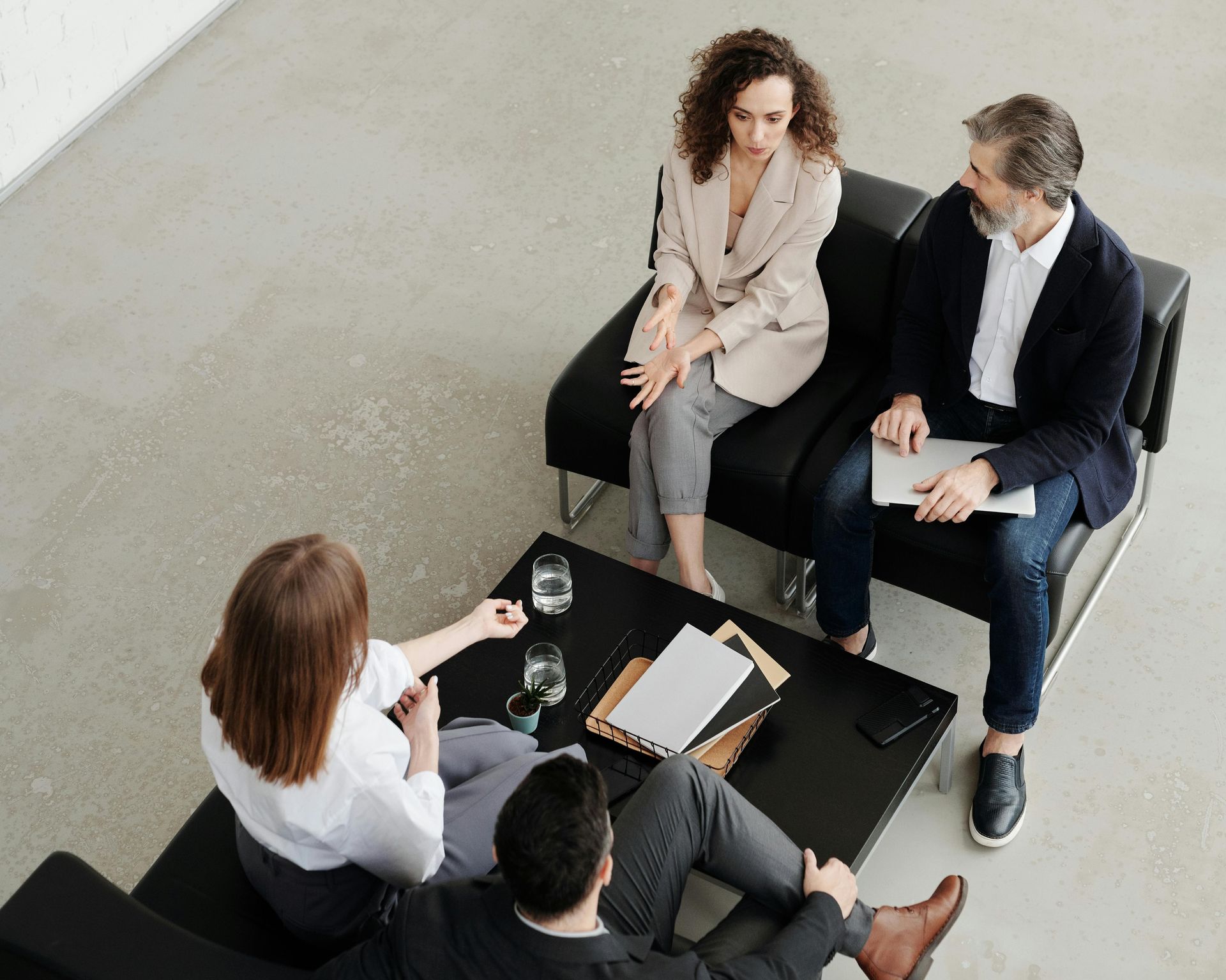 Four business people are sitting around a table discussing something