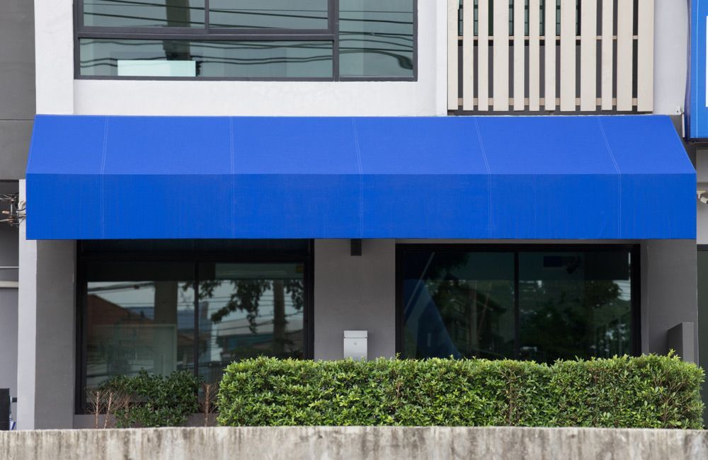 Blue Awning Over Glass Door — Expert Glaziers in Proserpine, QLD