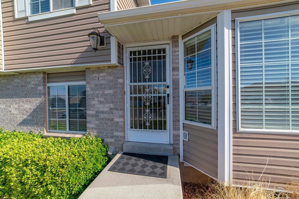 Front Exterior Of A House With Security Doors And Wall Lighting — Durable Security Doors in Bowen, QLD