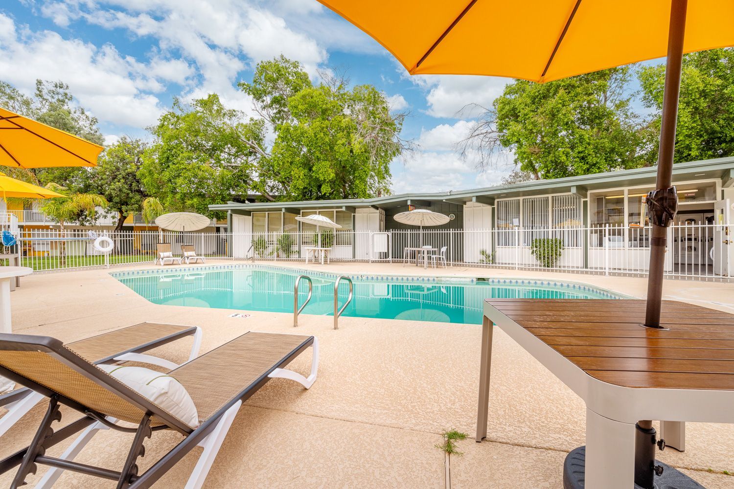 a swimming pool with chairs and umbrellas around it