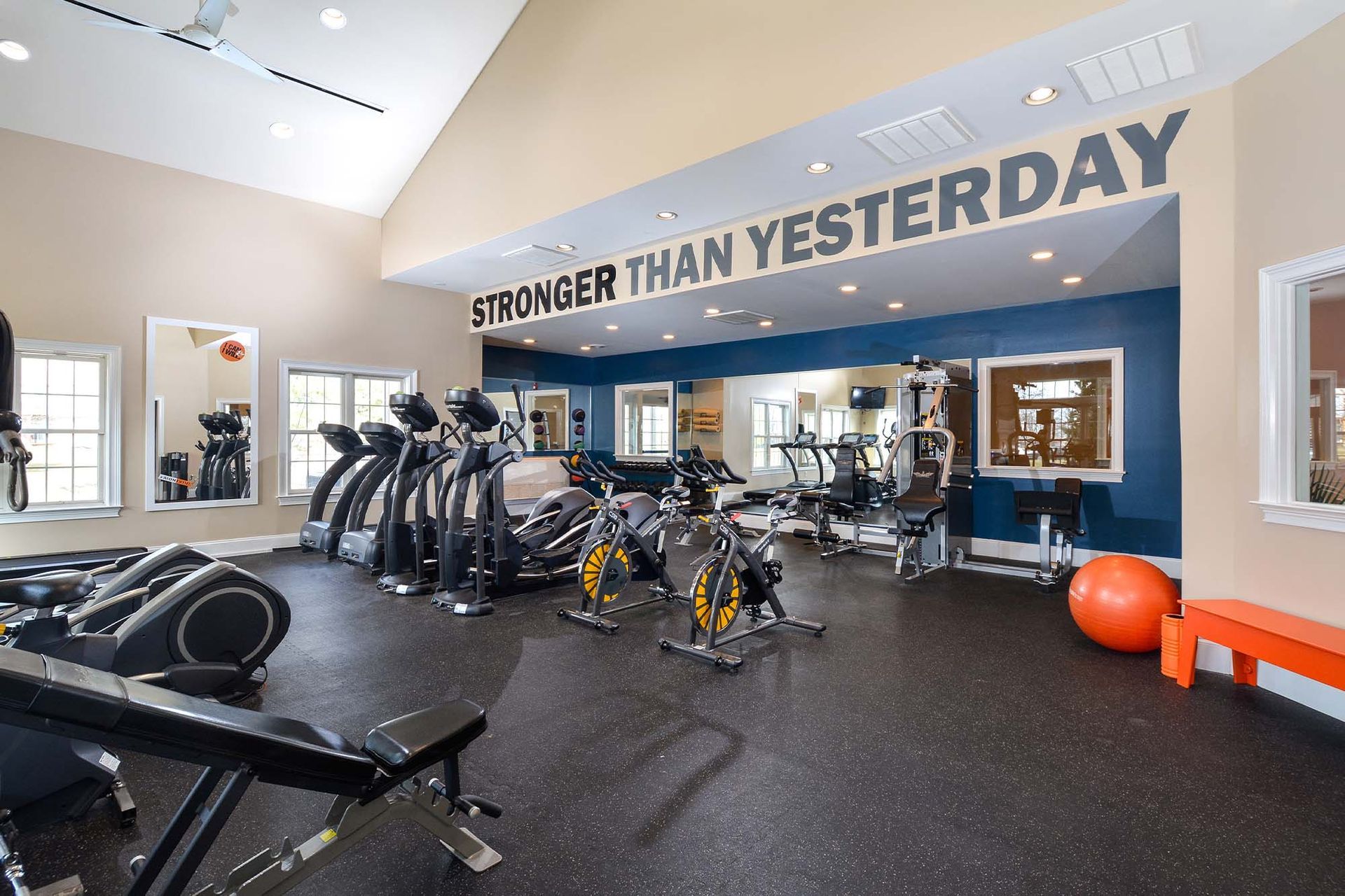 Interior of an apartment community fitness center with cardio machines and weight equipment.