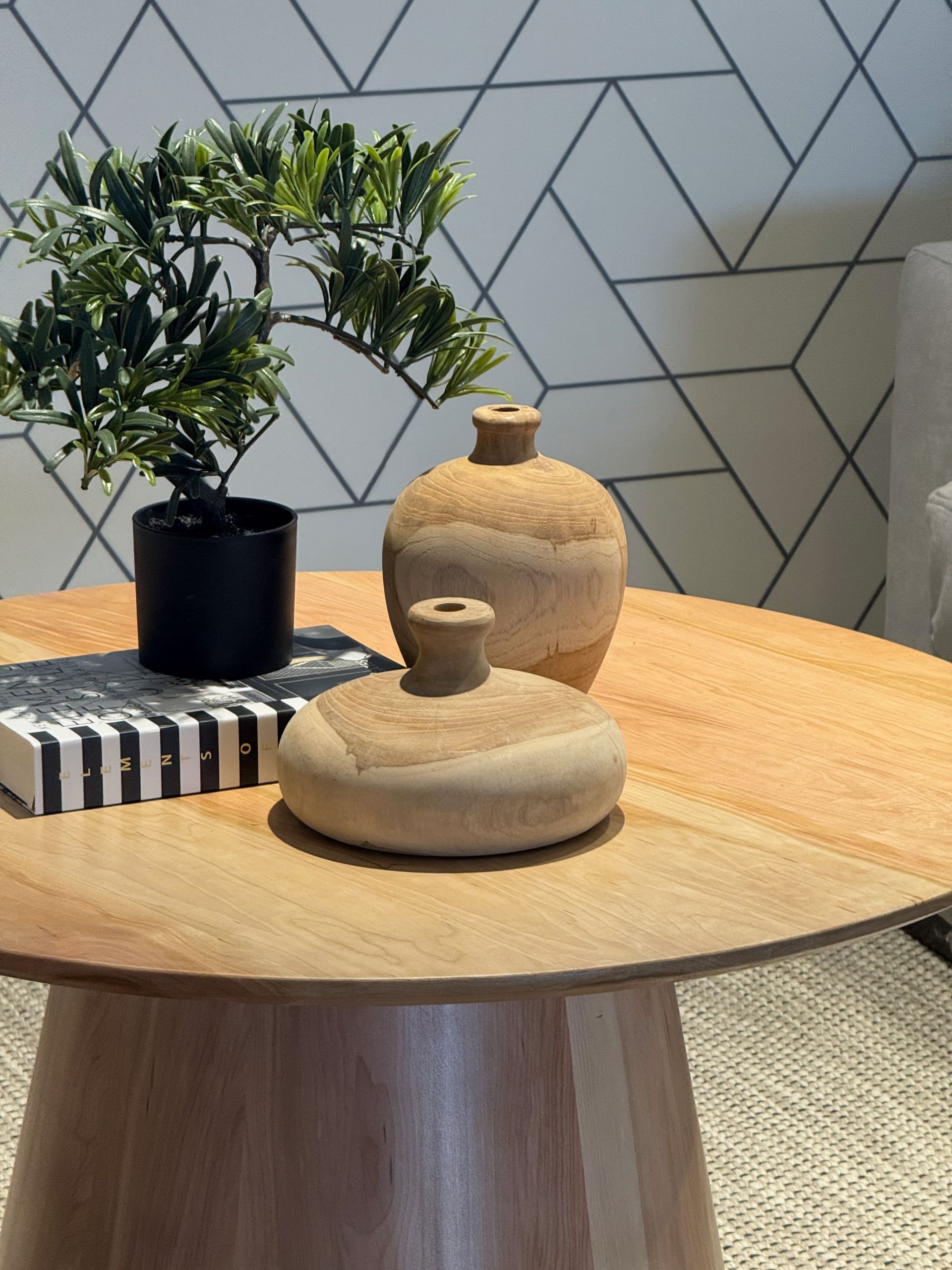 Mesa de madera con jarrones de cerámica beige.