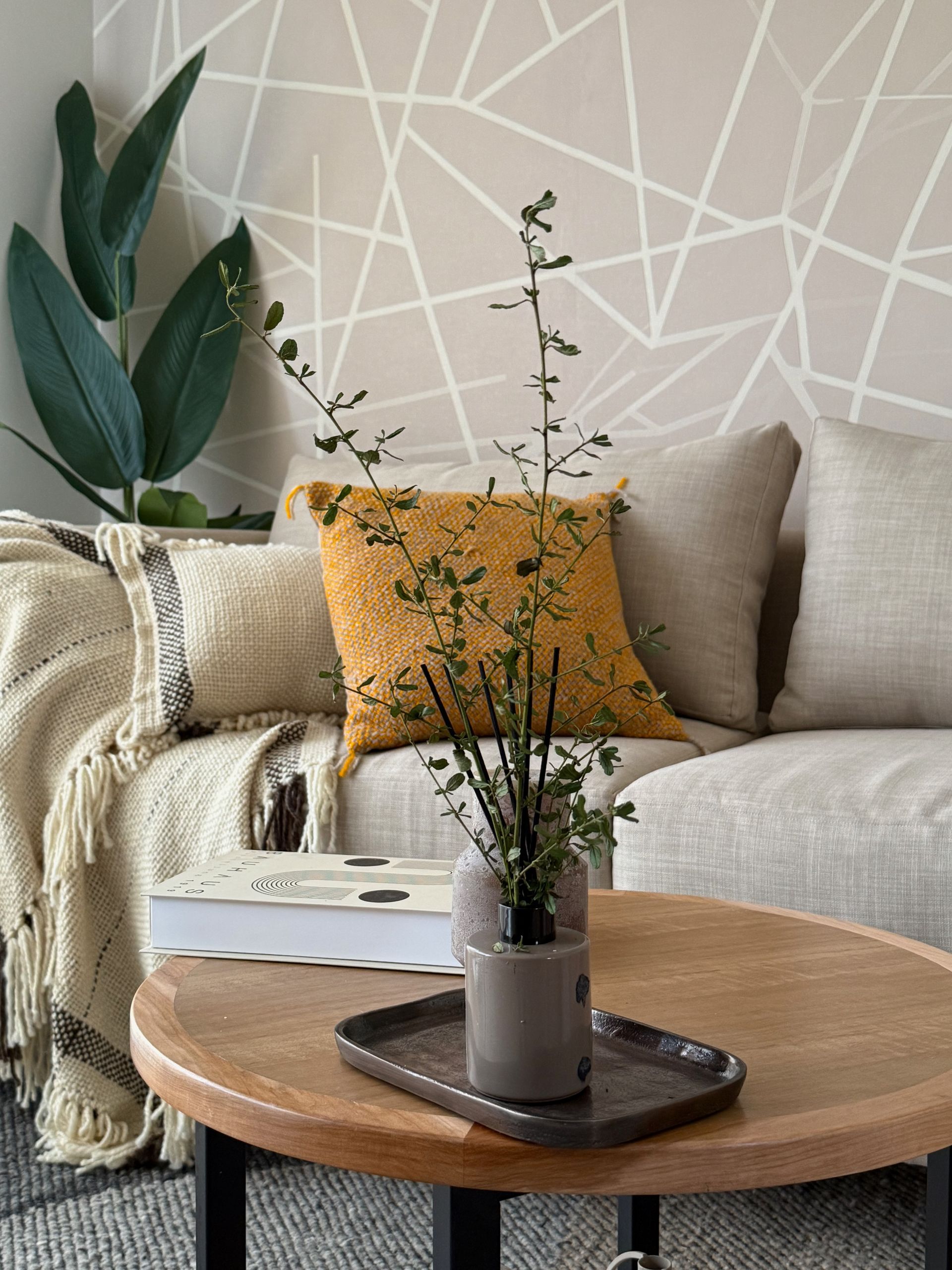 Acogedora sala de estar de color beige con un sofá, una mesa de centro de madera.