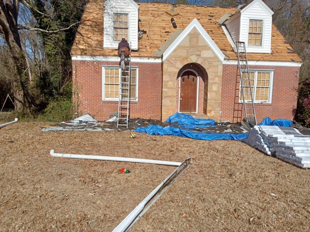 Brick house under renovation with blue tarps, white trim, and gravel yard