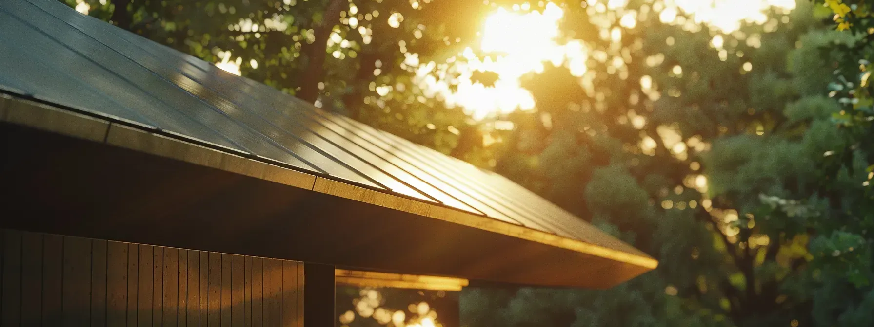 The sun is shining through the trees on the roof of a house.
