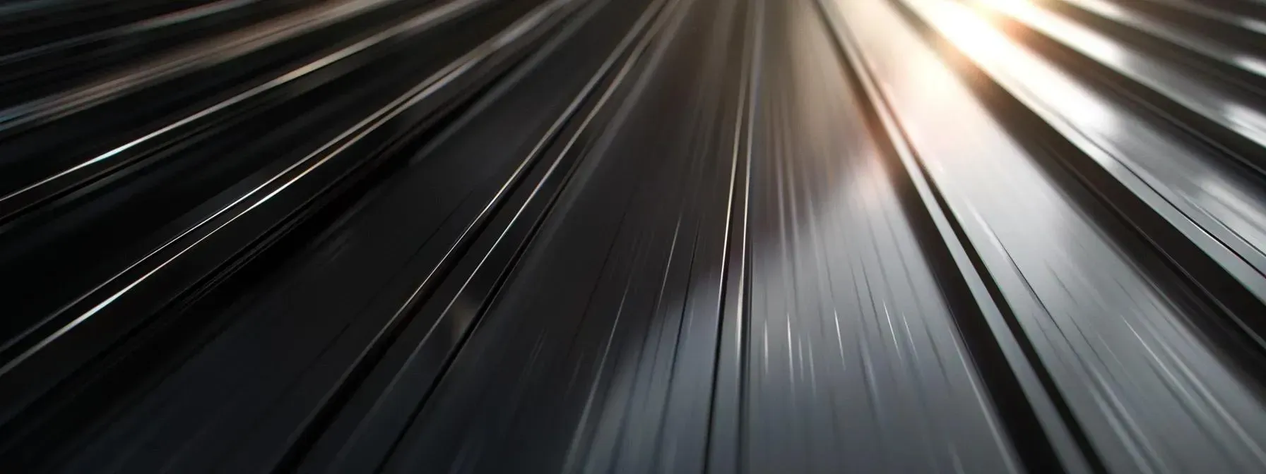 A close up of a train track with the sun shining through the tracks.