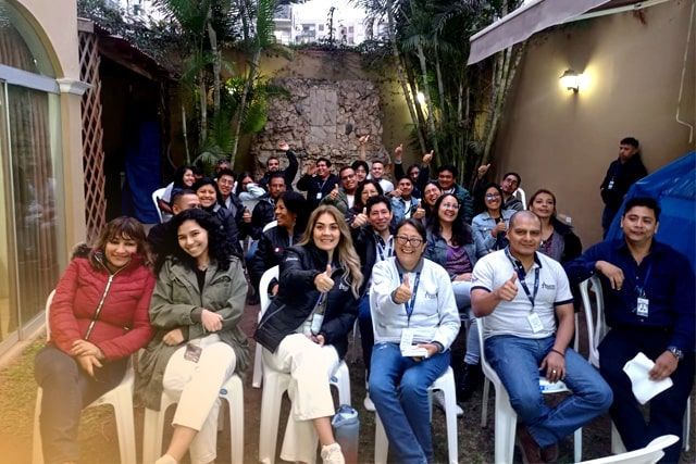 Un grupo de personas está sentada en sillas y levantando el pulgar.