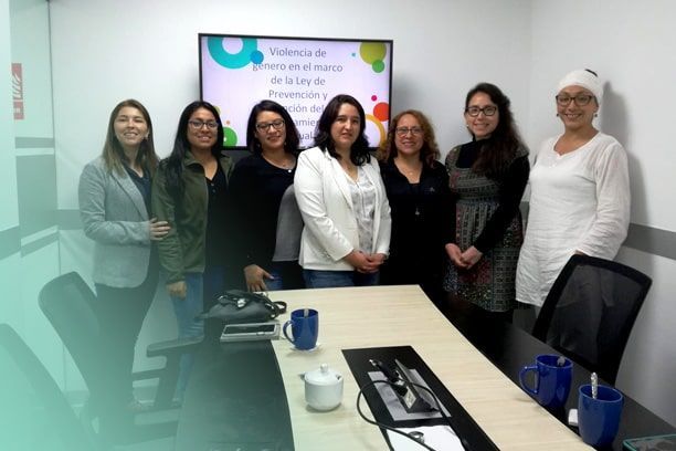 Un grupo de mujeres está de pie alrededor de una mesa de conferencias.