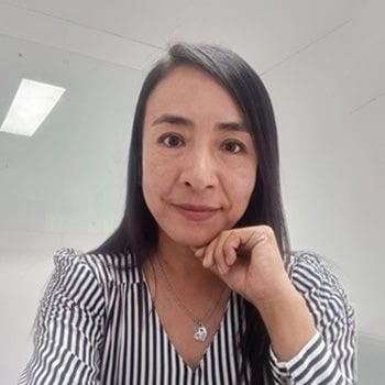 La mujer lleva una camisa a rayas y un collar.