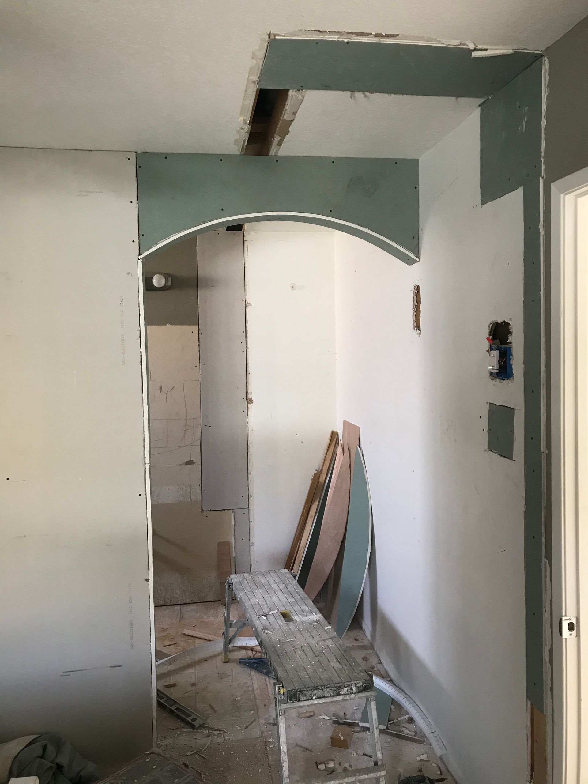 A room with a ladder and a bench in it is being remodeled.