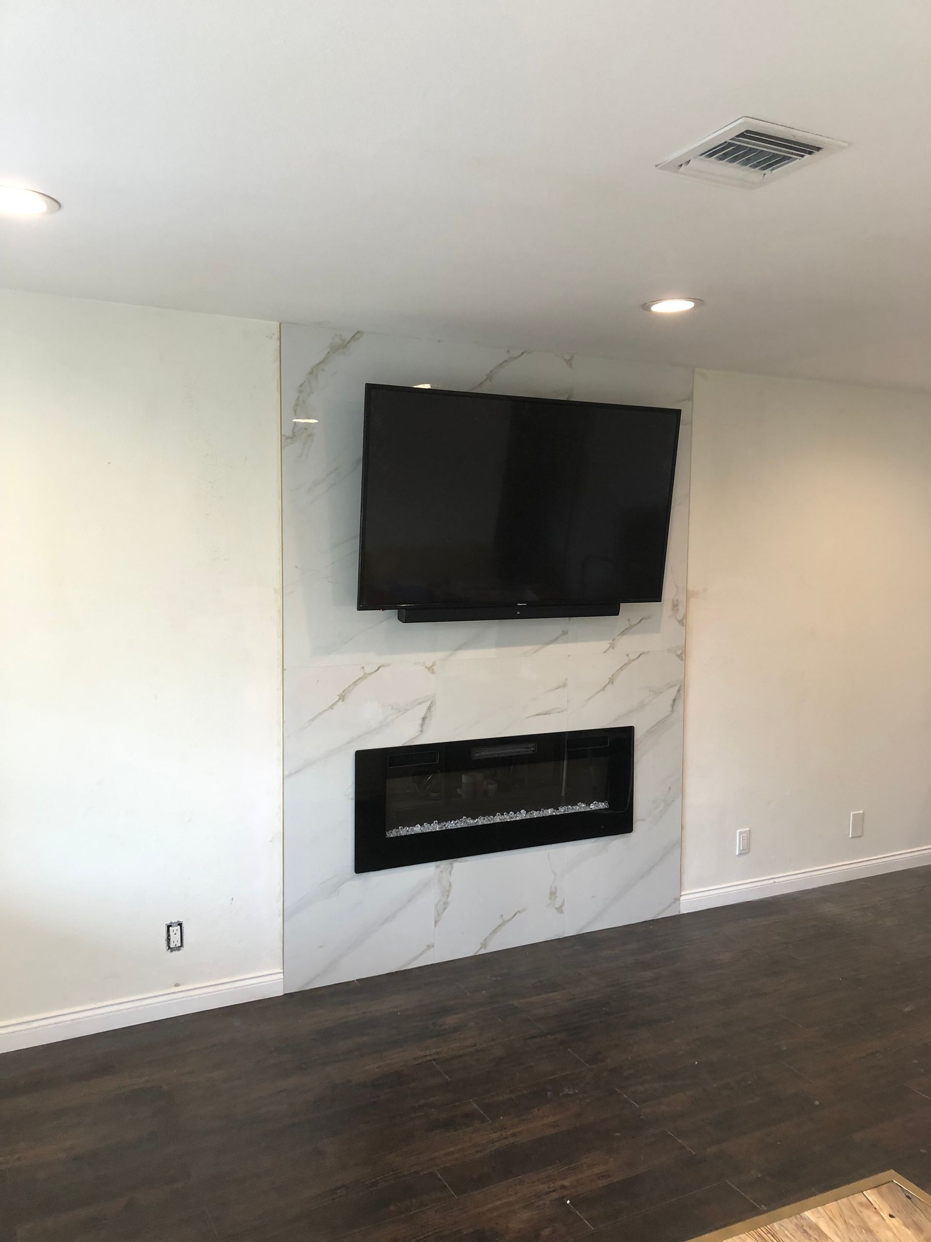 A living room with a fireplace and a flat screen tv