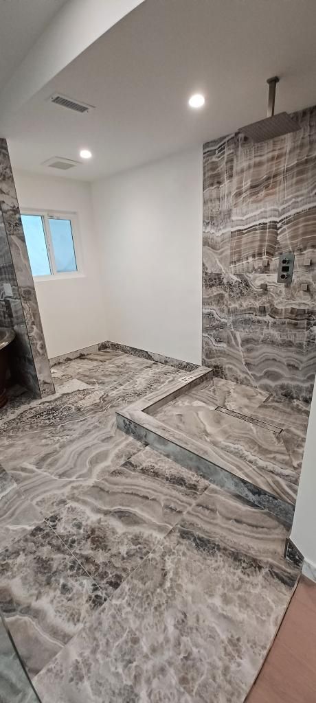 A bathroom with a walk in shower and a fireplace.