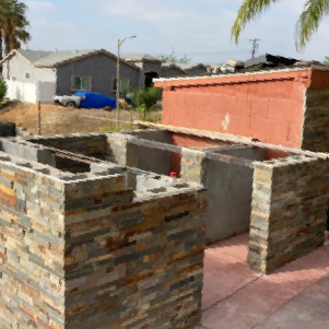 A brick wall with a red building in the background