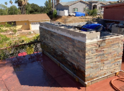 A brick wall is being built on the roof of a house.