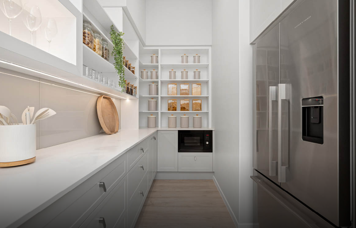 Bright modern galley kitchen with white shelves, gray cabinets, and stainless-steel appliances.