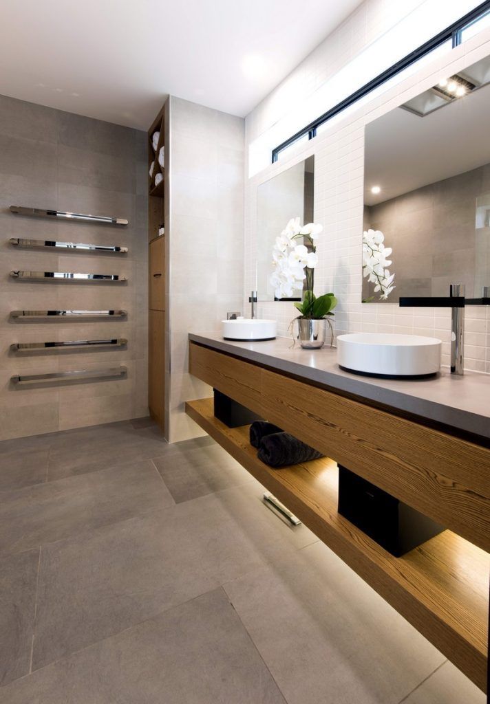 Modern bathroom with floating wooden vanity, large mirror, and built-in towel shelves.