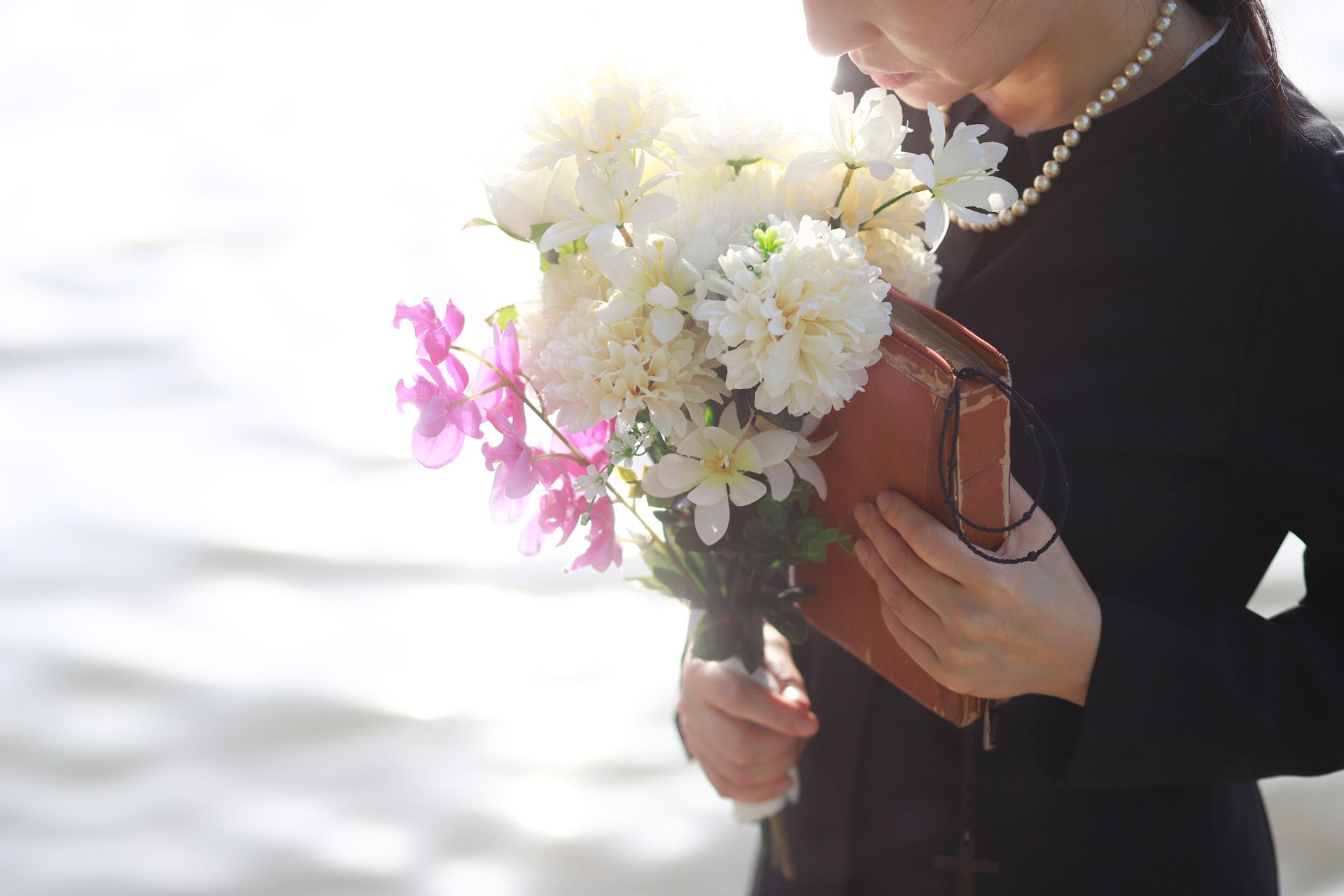 Holding Bible and Flowers — Griffith, NSW — Griffith & District Funerals