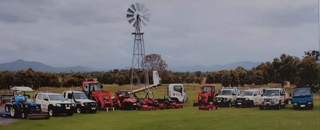 Group Of Vehicles Are Parked In A Field With A Windmill In The Background — Wetzler Pty Ltd In Marmor QLD