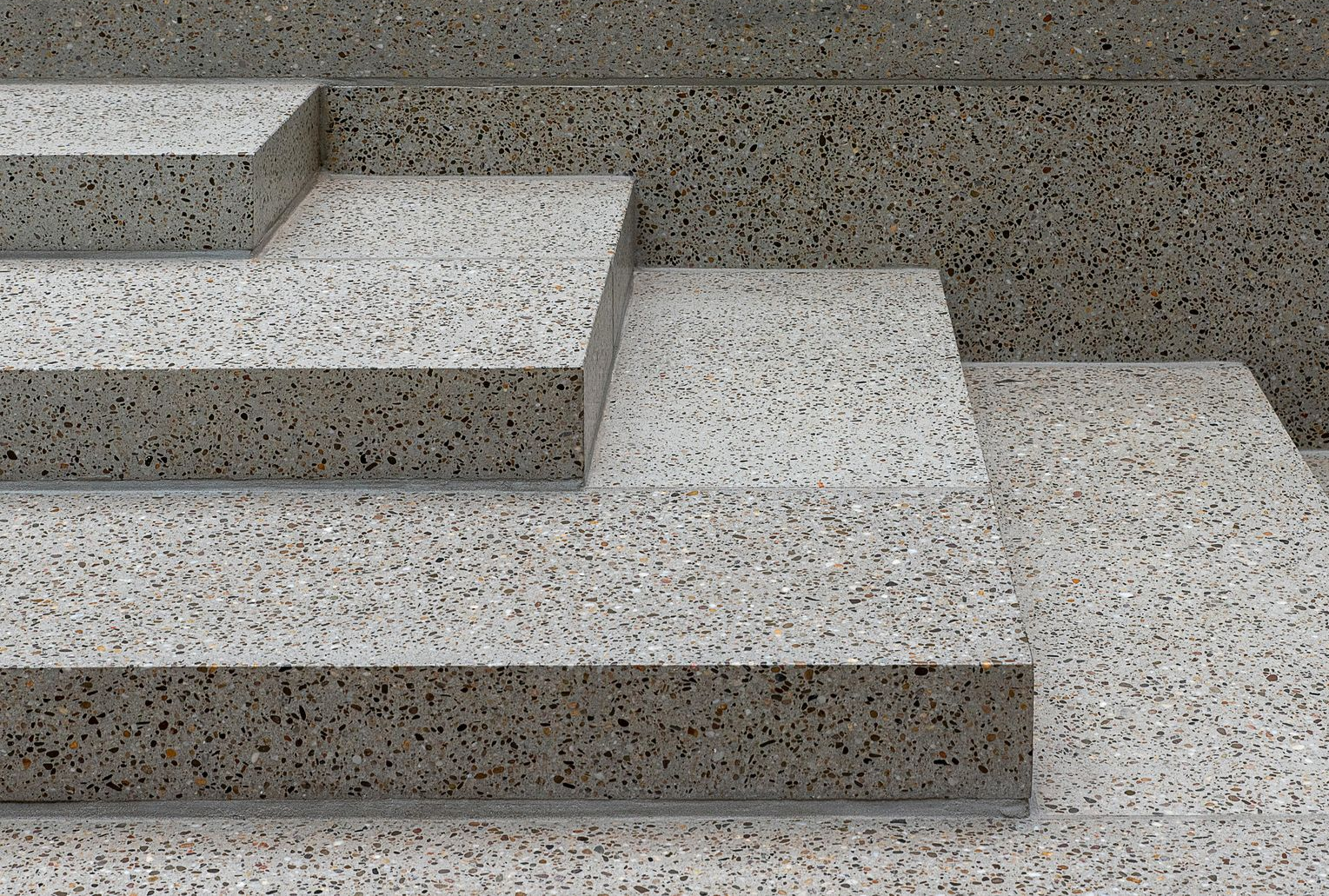 Gray concrete steps with textured surfaces against a gray background