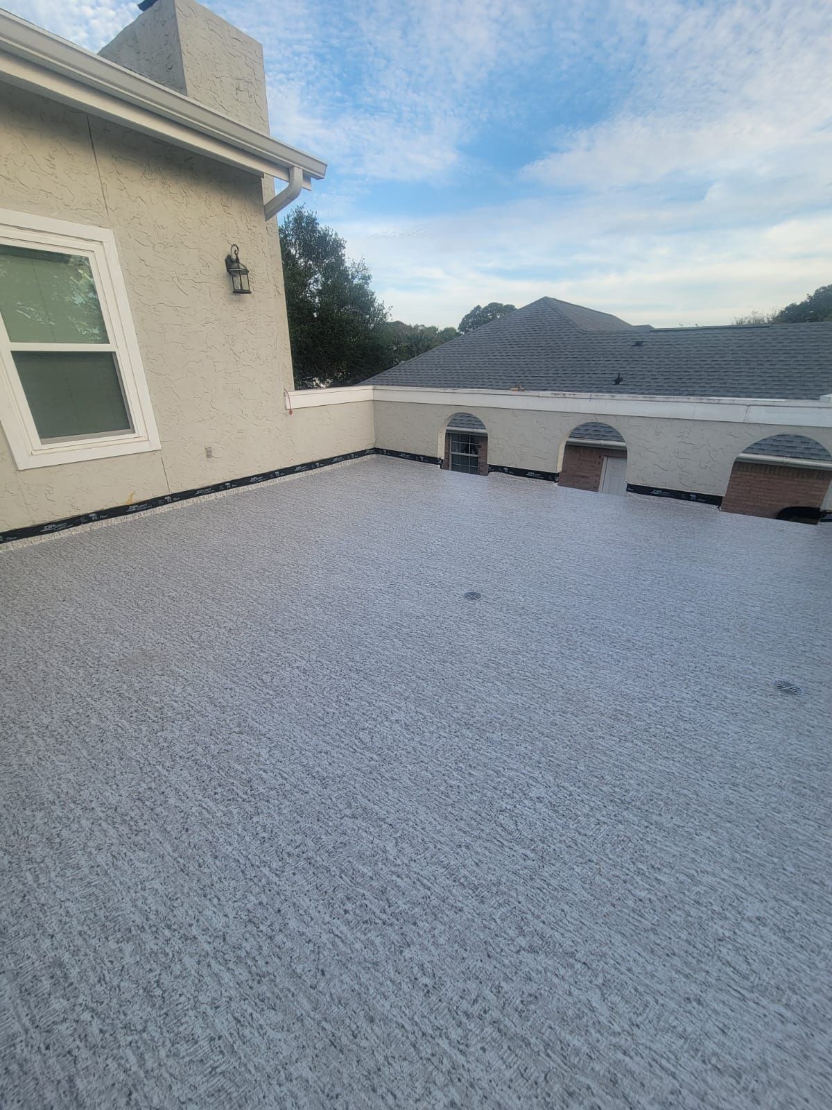 Professional Duradek waterproof deck membrane installation on a Florida balcony with finished edge and flashing details