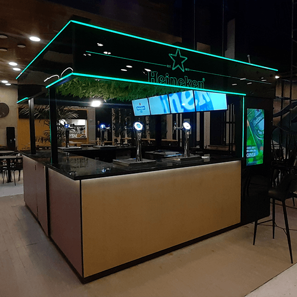 Um restaurante com uma placa da Heineken acima do balcão