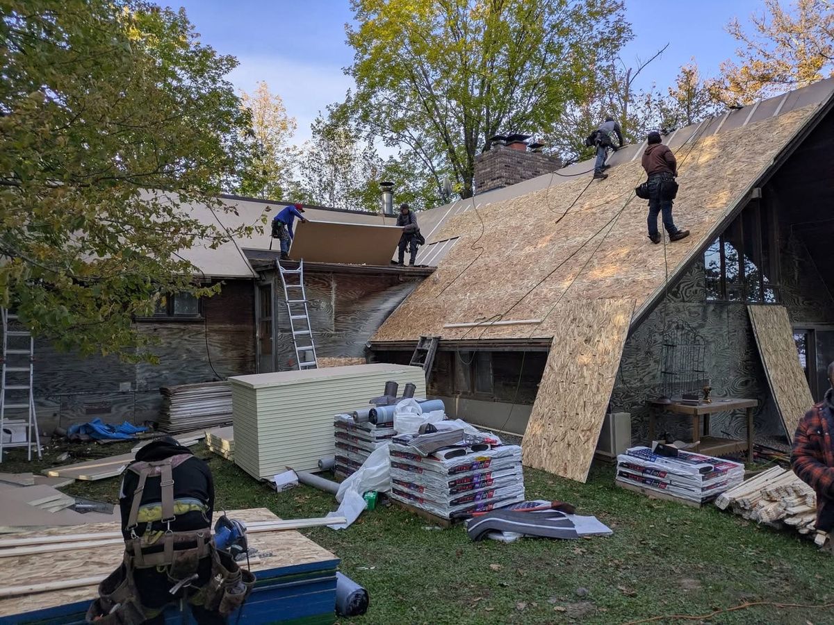 Installing insulation and roof decking for a secondary roof system on an older A-frame cabin in MN