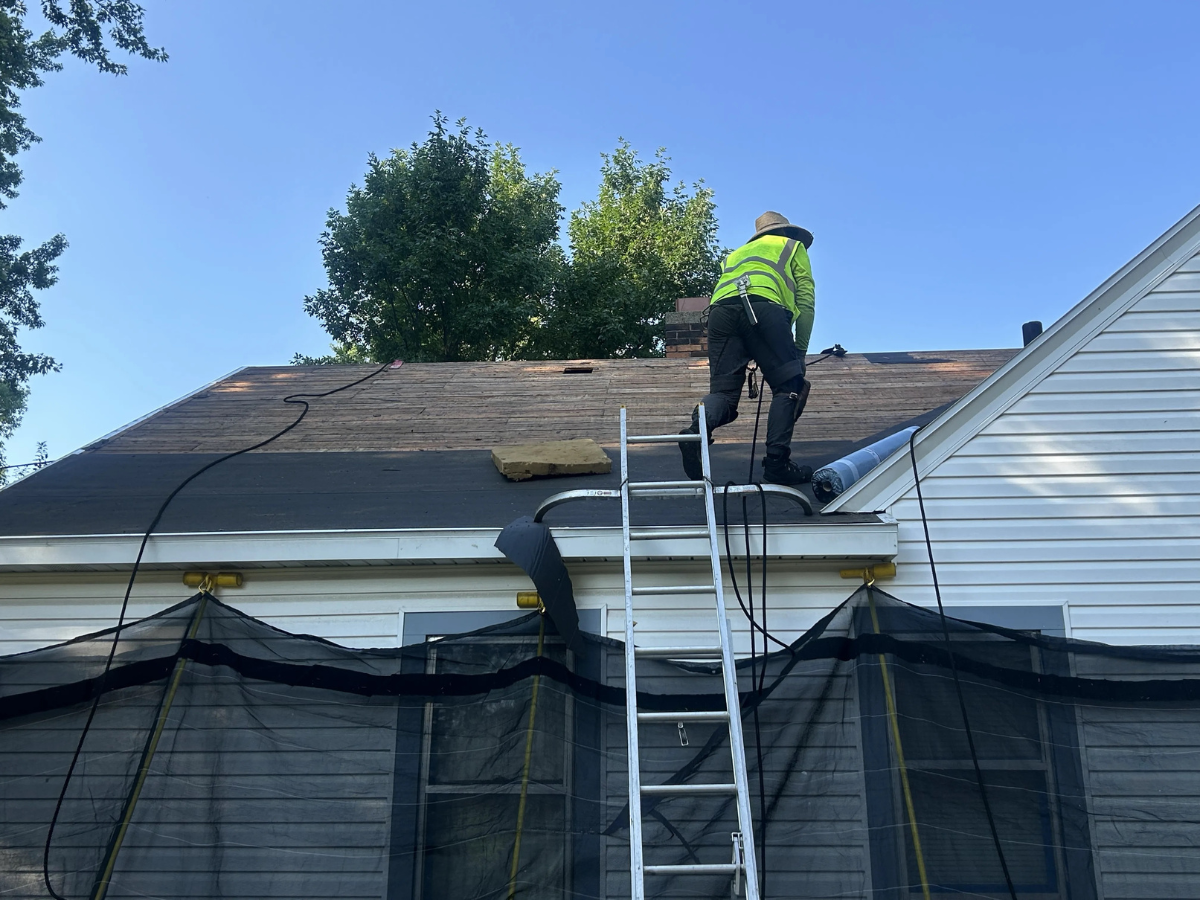 Roofing professional working on the exposed roof deck during a tear-off in Wadena, Minnesota.