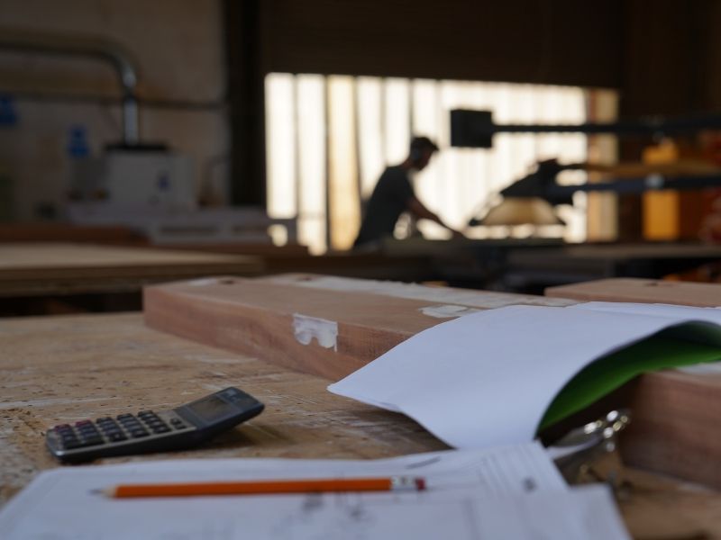 Desk with papers, pencil, calculator blurred workspace
