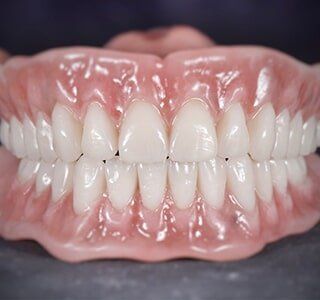 A Close Up of a Person's Teeth With a Full Denture