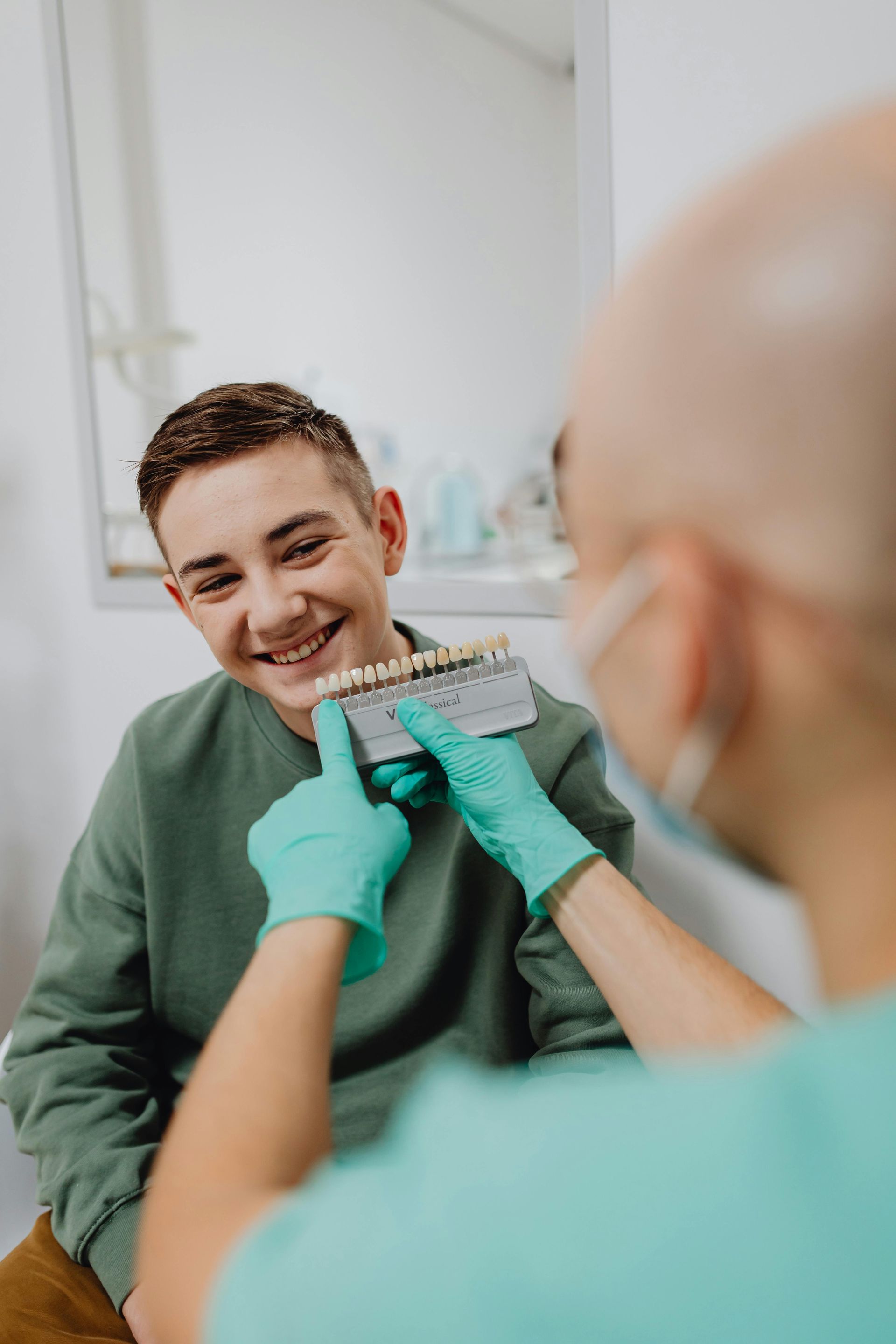 A dentist is holding a model of a boy 's teeth. — The Denture Kitchen in Maroochydore, QLD