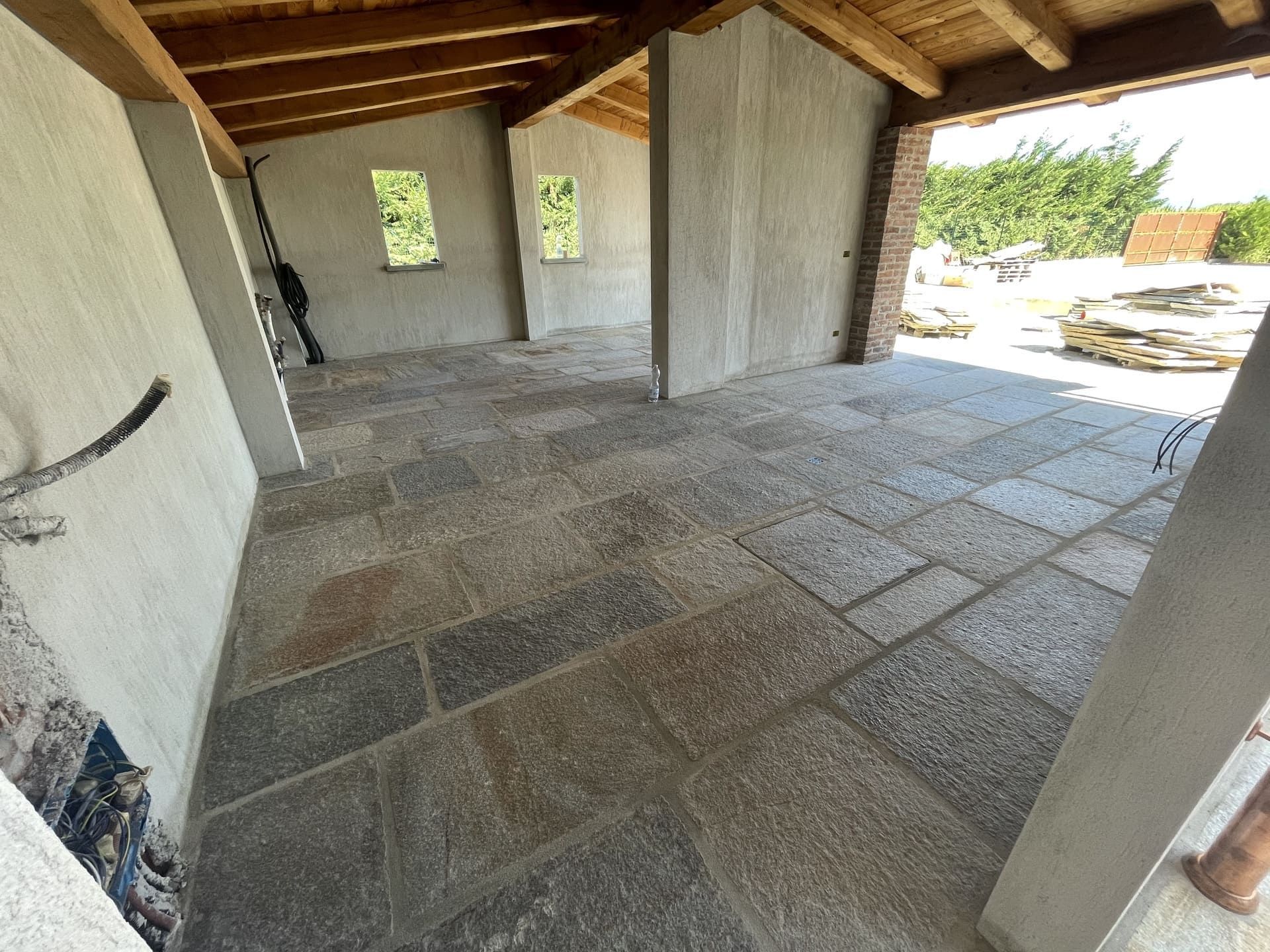 Pavimentazione in pietra di pietra grigia, pareti grezze, travi in legno e due piccole finestre.