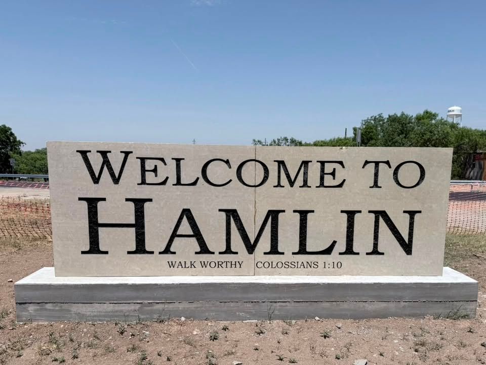 Stone “Welcome to Hamlin” town sign in a sunny outdoor setting