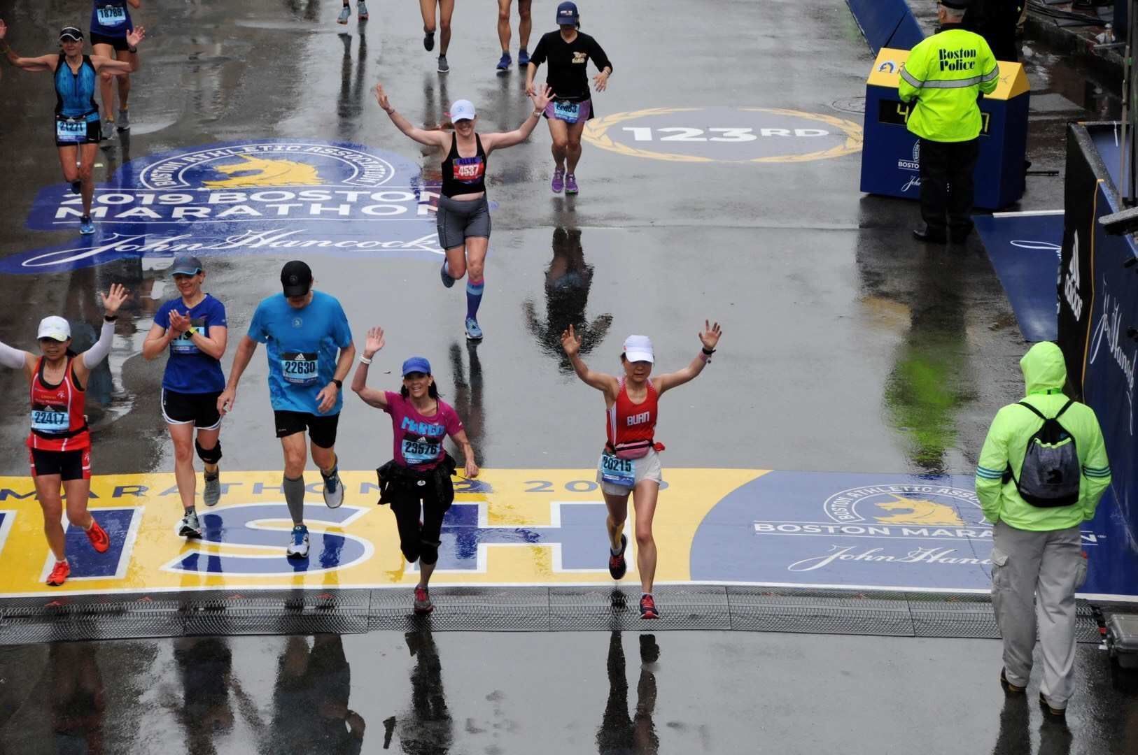 A group of people are running a marathon in the rain.