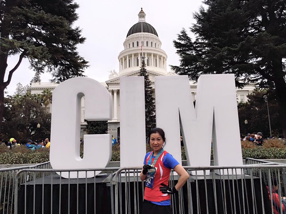 A woman stands in front of a sign that says glm