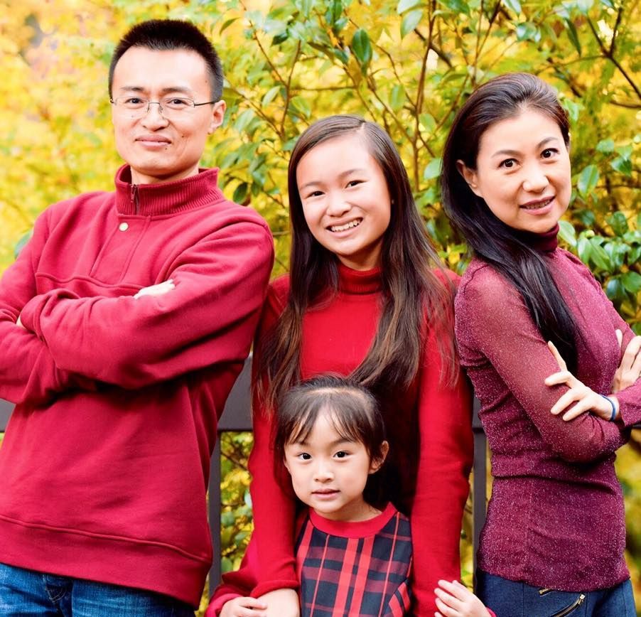 A group of people standing next to each other with their arms crossed